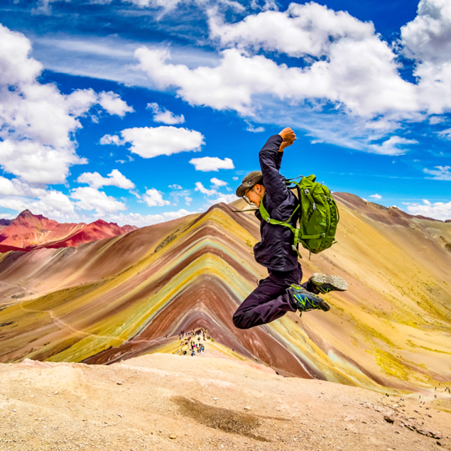turista saltando en la montaña de siete colores